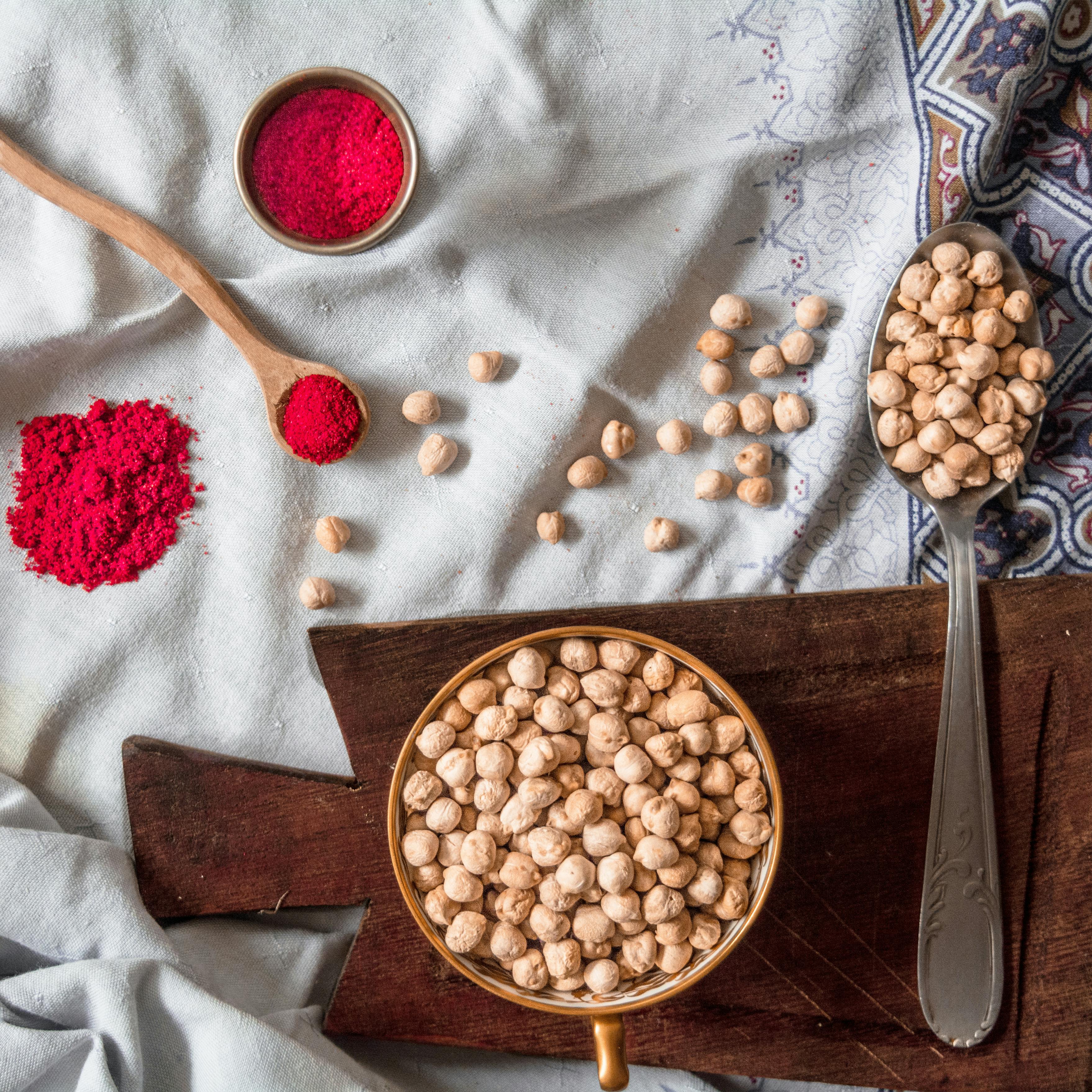 A flat lay of chickpeas and red spice on a rustic cloth, perfect for culinary inspiration.